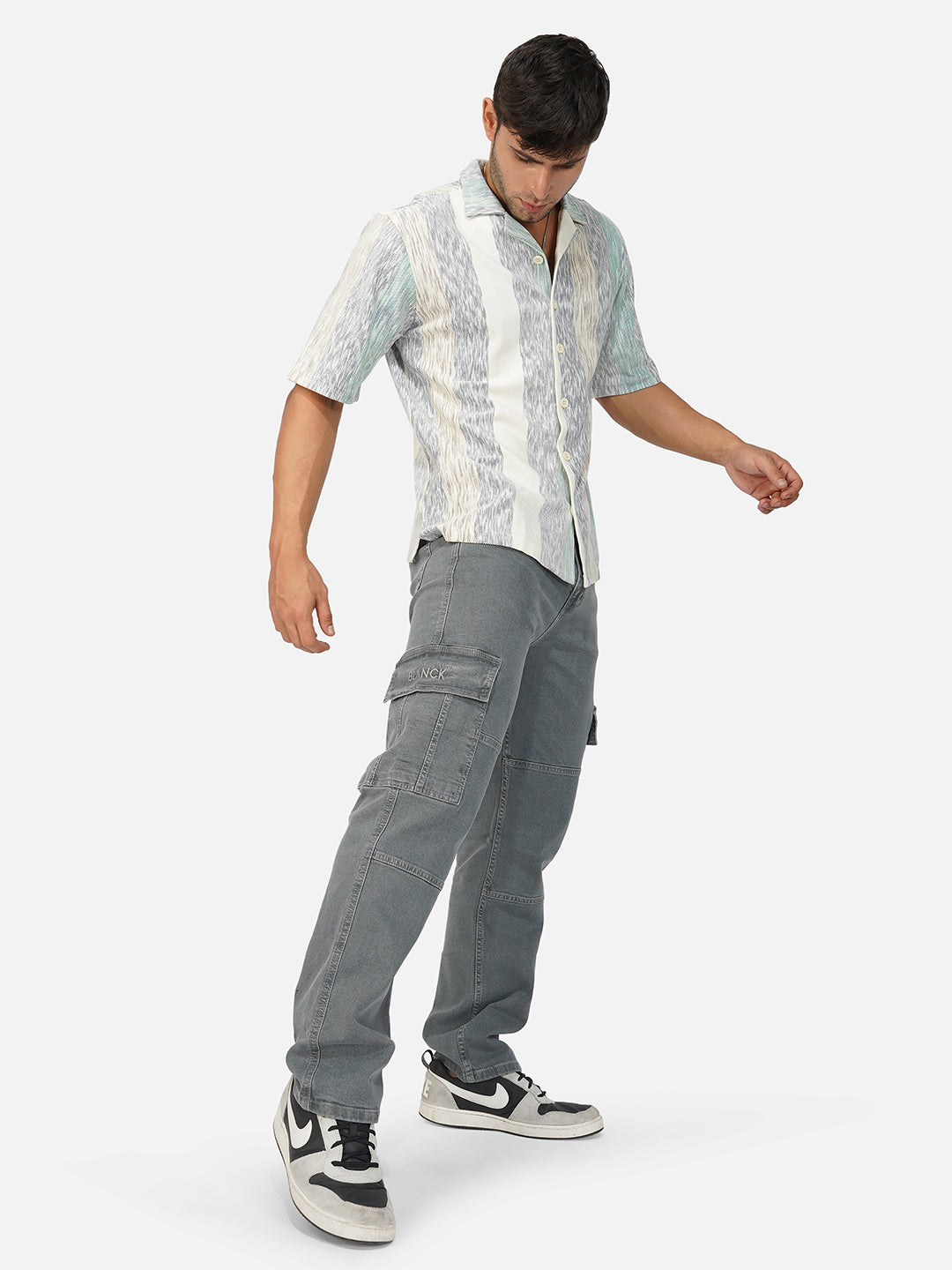 Model wearing relaxed-fit grey cargo jeans with flap pockets