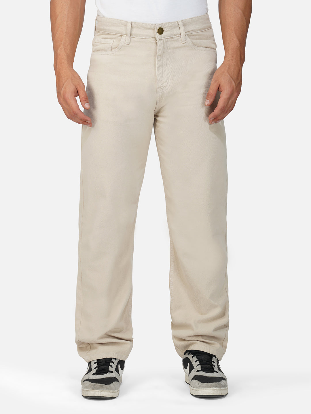 Model wearing ecru comfort jeans showcasing front pockets and relaxed fit.