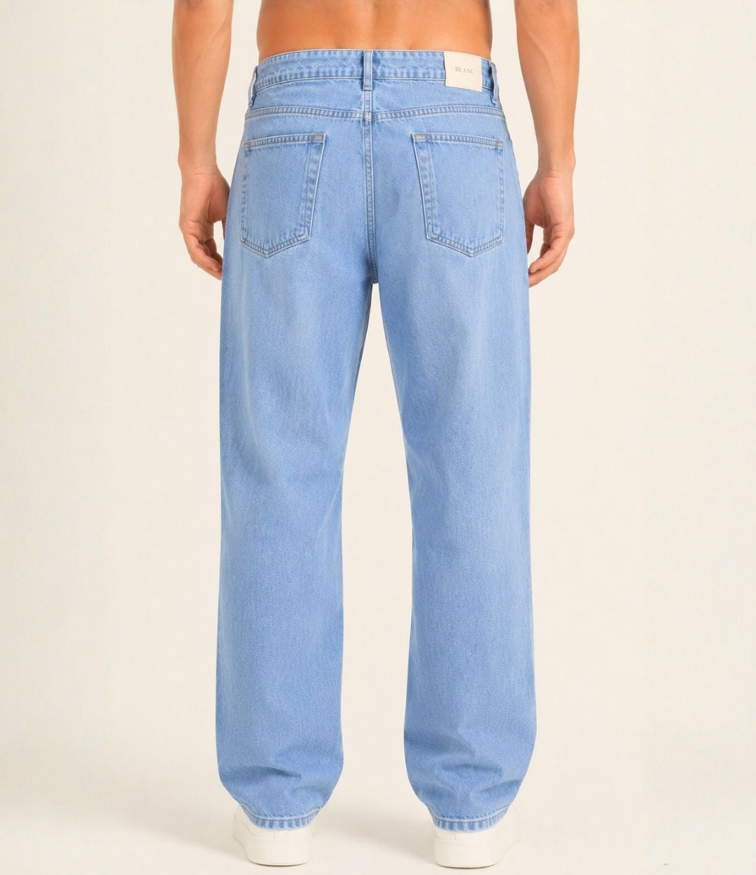 Light blue jeans worn by a person on a plain background